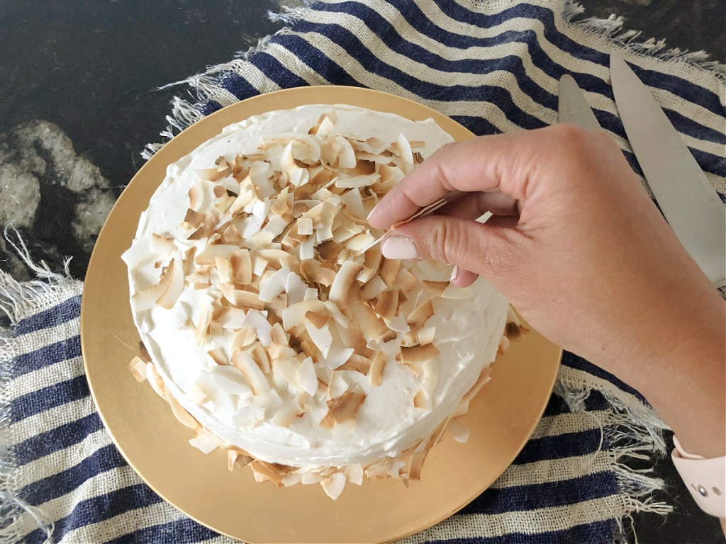 putting coconut on keto coconut cake