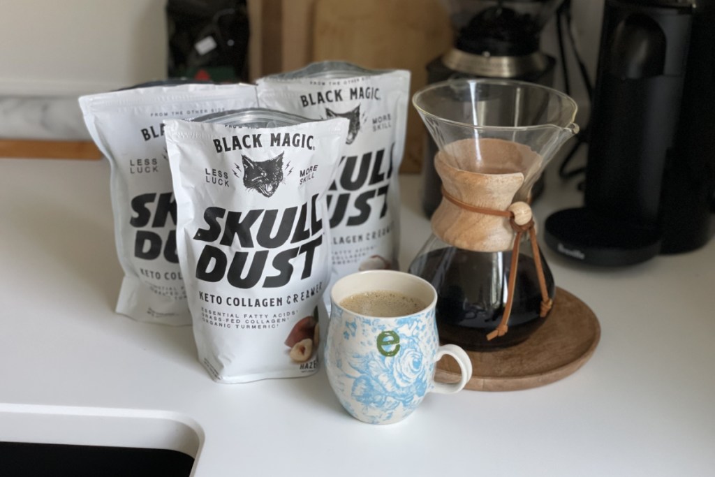 bags of Skull Dust collagen creamer behind coffee cup