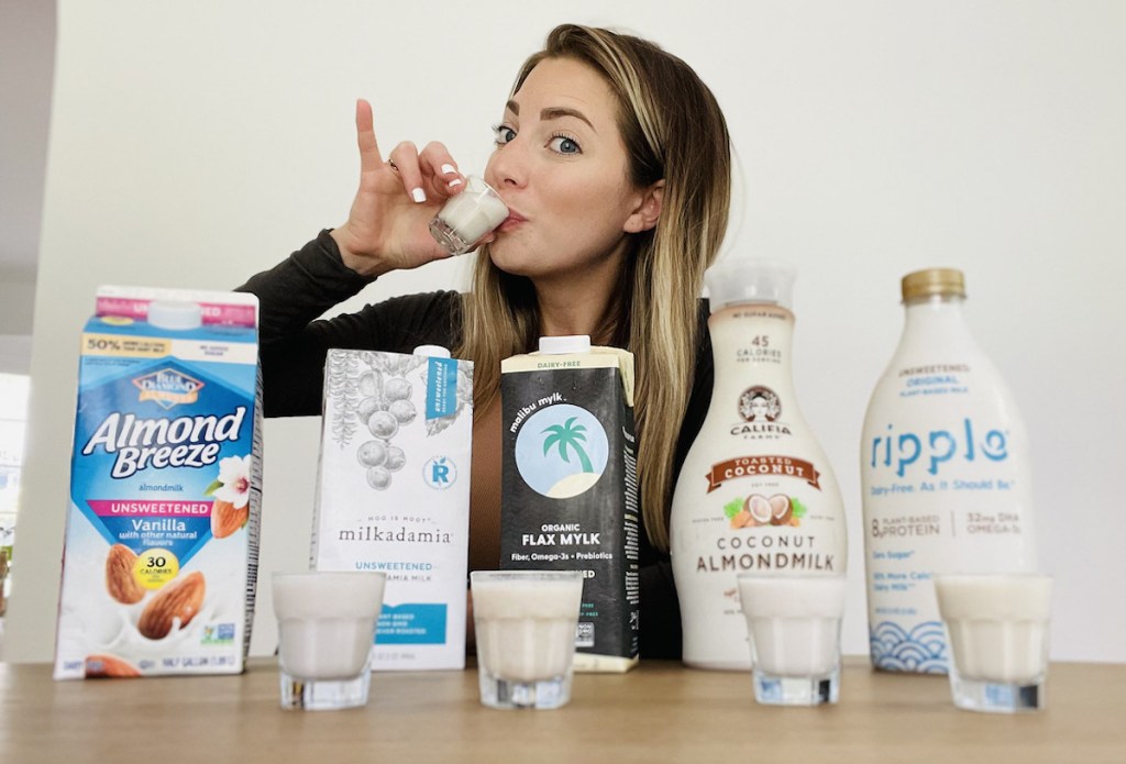 woman with pinky up sipping from shot glass with dairy free milk inside