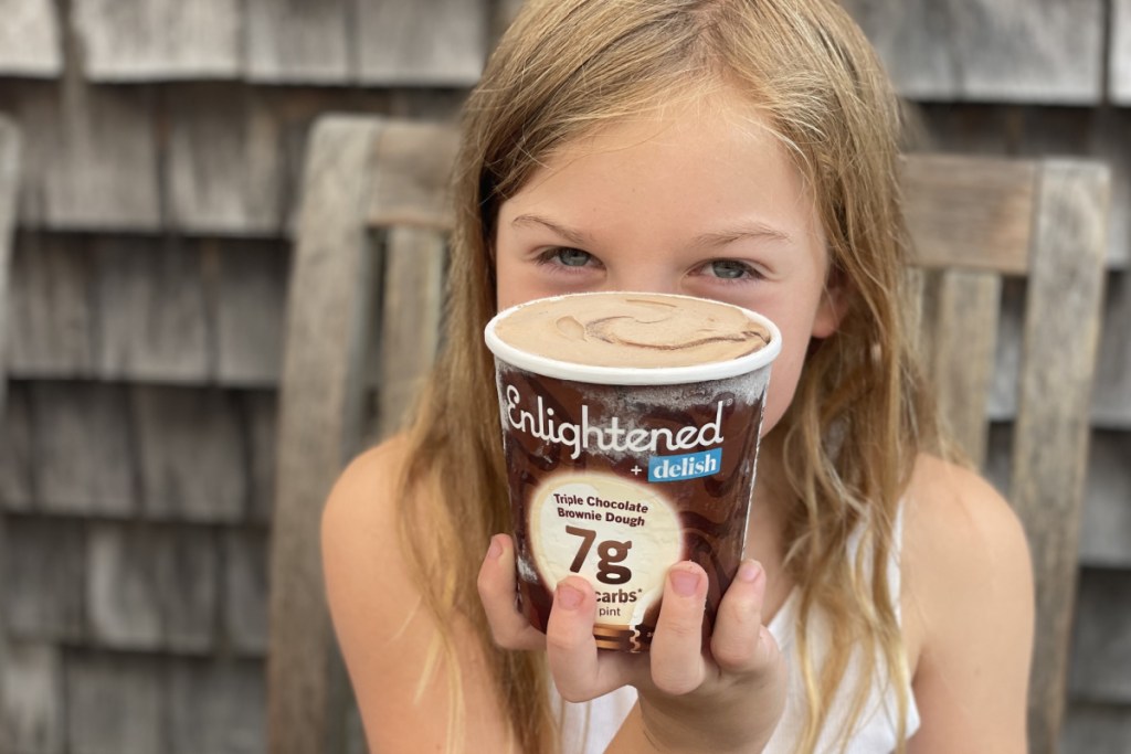 little girl holding pint of Enlightened keto ice cream