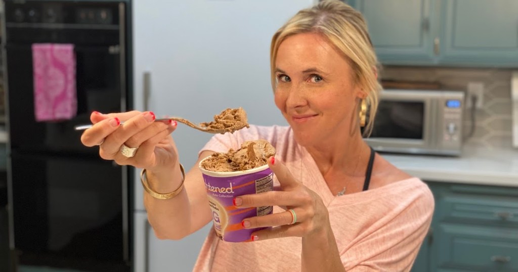 Woman holding up a spoonful of Enlightened keto ice cream