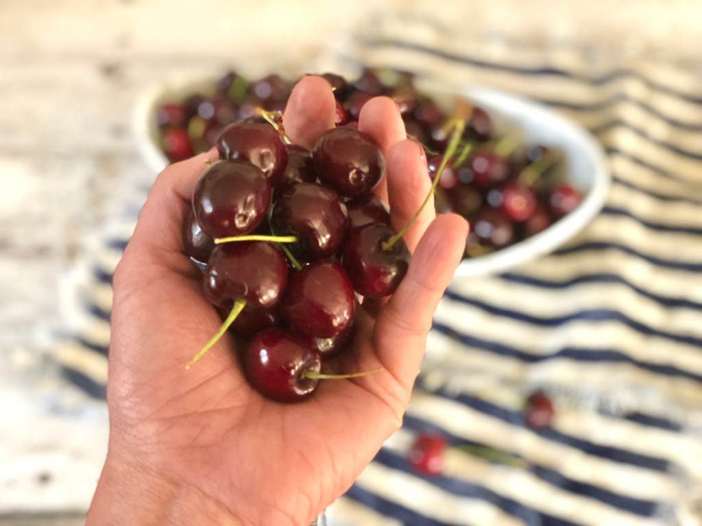 a hand holding cherries