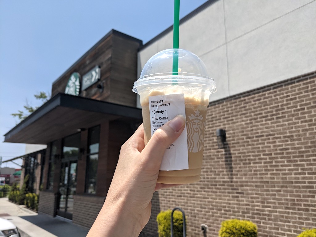 holding Starbucks drink outside 