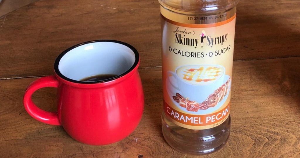 bottle of sugar-free syrup next to red mug