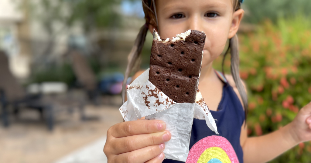 little girl holding keto ice cream sandwich outside