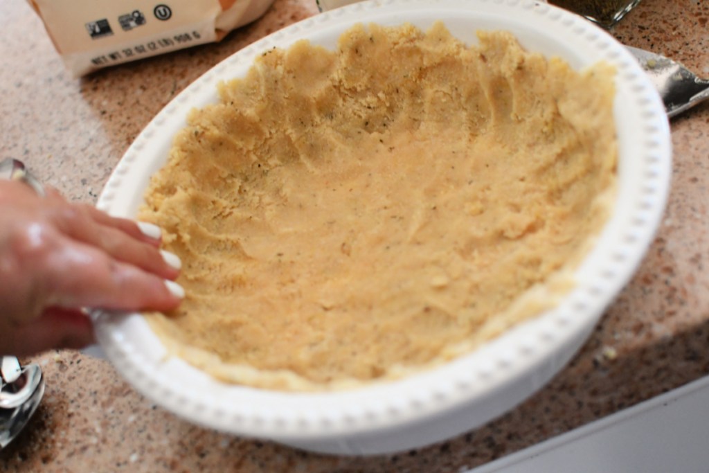 pressing a keto pie crust into pan