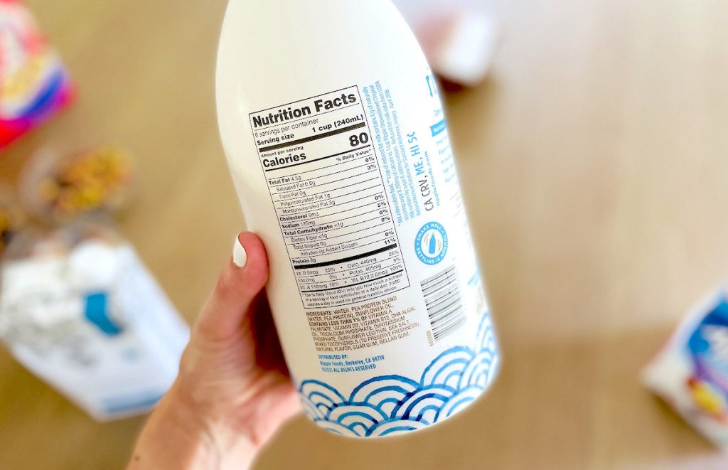 hand holding a container of ripple dairy free milk with ingredients label showing