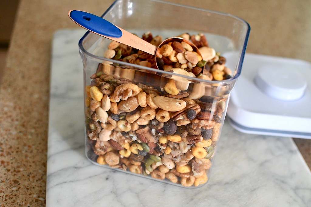 keto trail mix in container with measuring cup