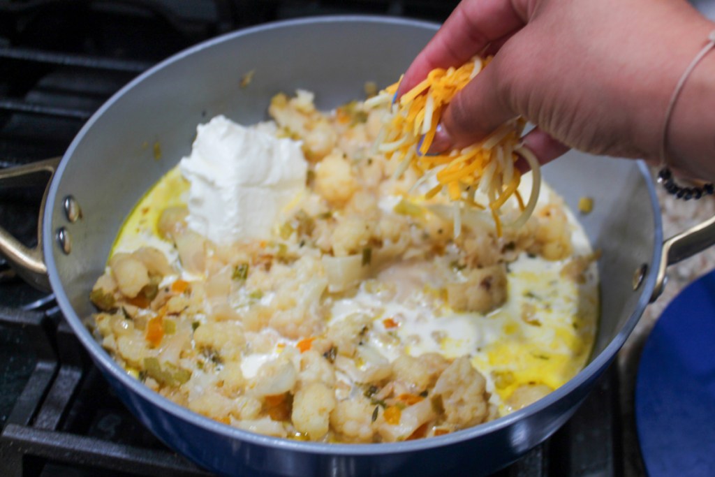 Sprinkling cheese onto low carb cauliflower soup