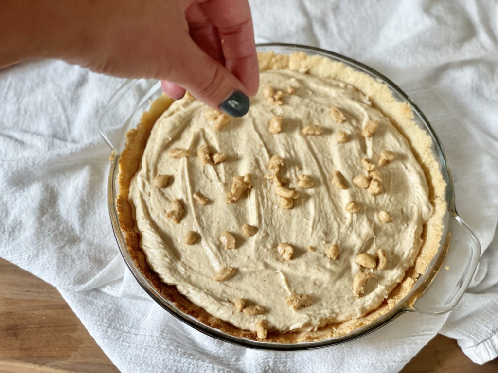 adding topping to keto peanut butter pie