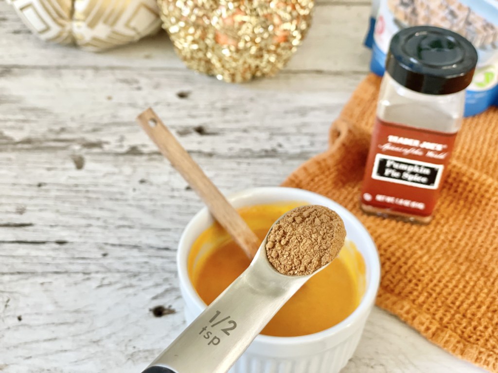 Keto Pumpkin Mug Cake batter adding pumpkin pie spice