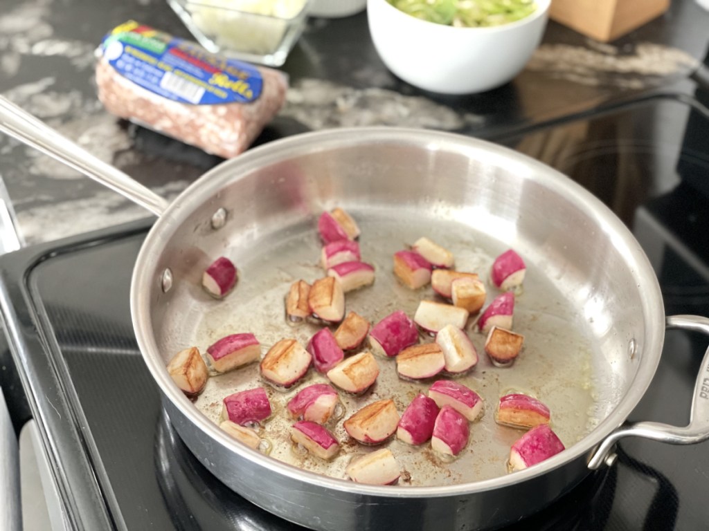 radishes cooking in a skillet for keto sausage hash