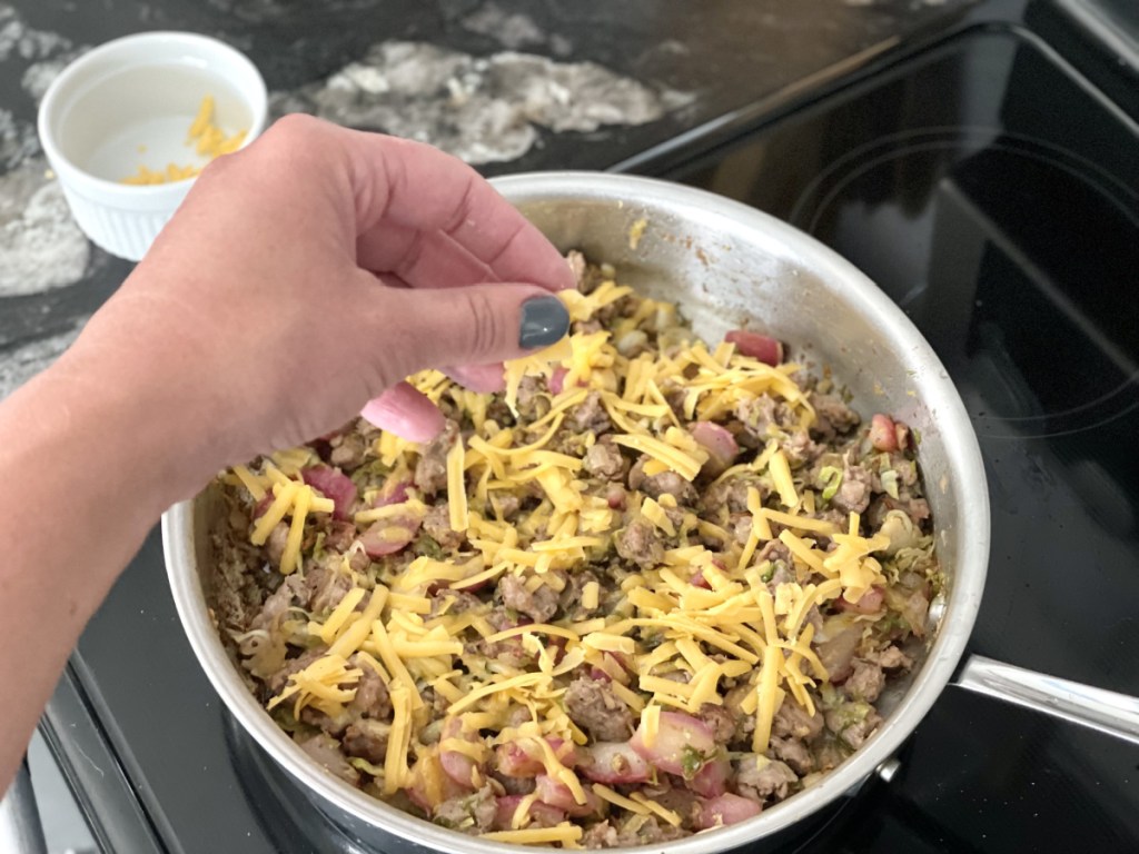 adding cheese to sausage hash