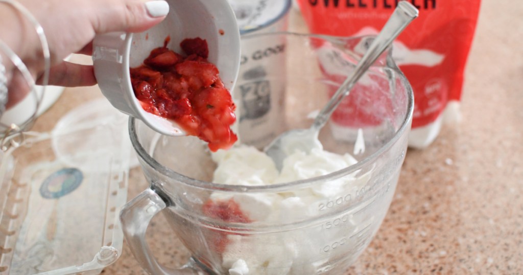 adding strawberries to plain yogurt