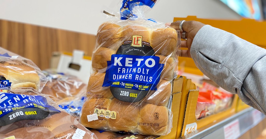 hand holding package of aldi keto bread dinner rolls