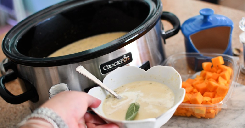 holding a bowl of keto butternut squash soup