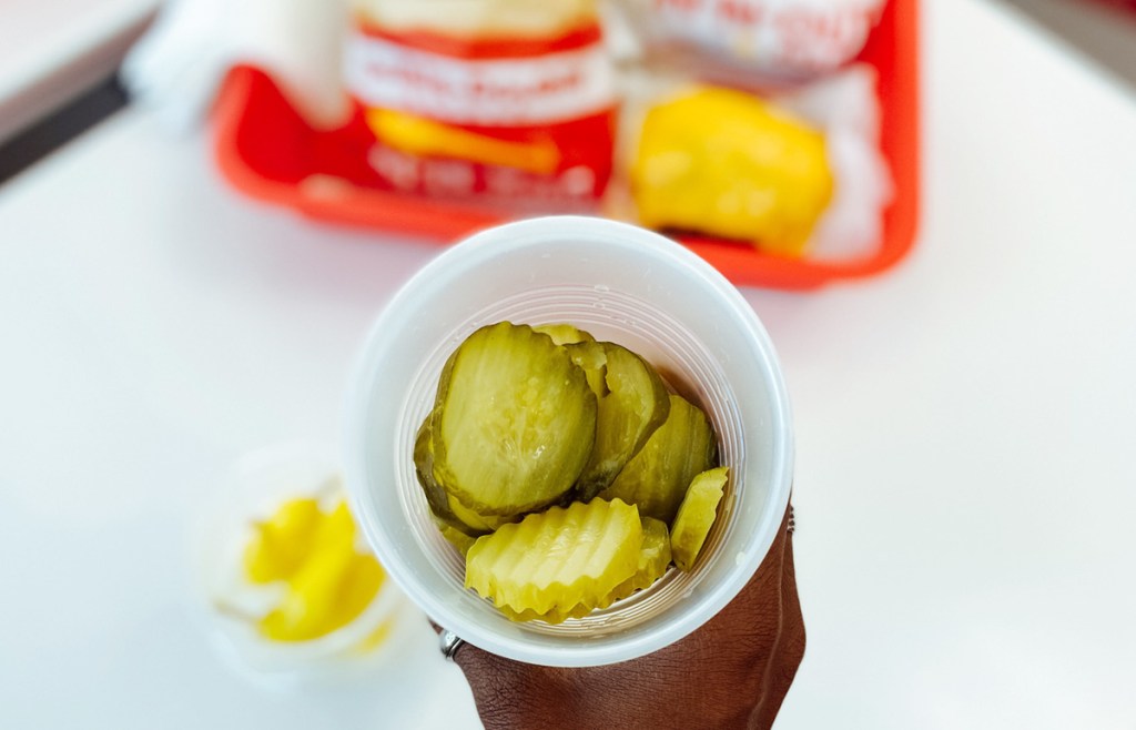 holding a cup of pickles