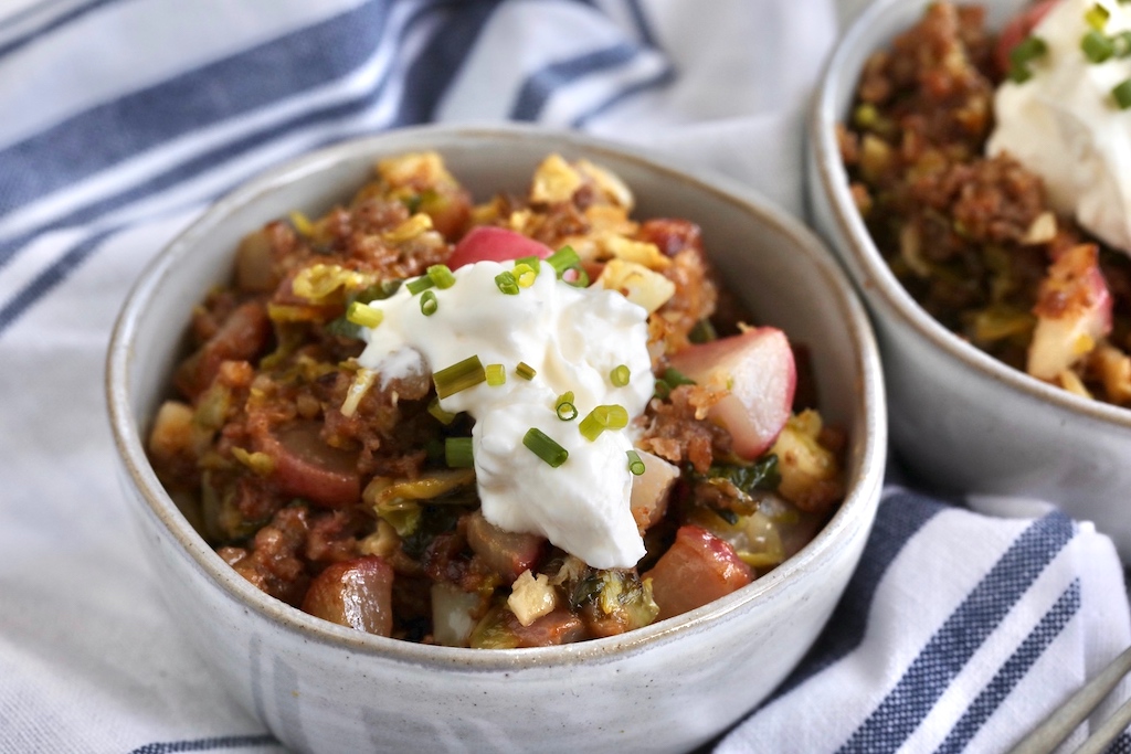 close up of keto sausage hash with sour cream in a bowl 