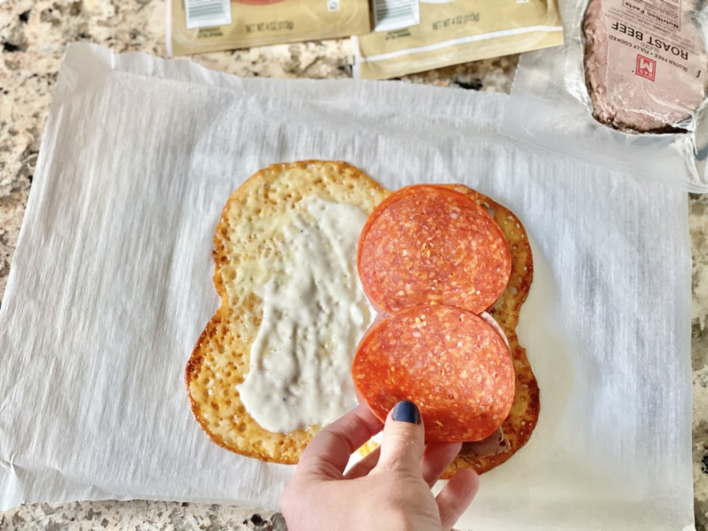 putting pepperoni on Keto Cheese Wrap