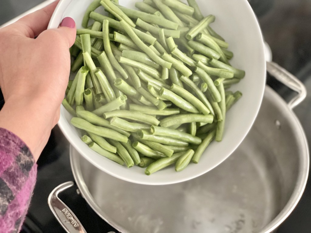 adding green beans to boiling water 