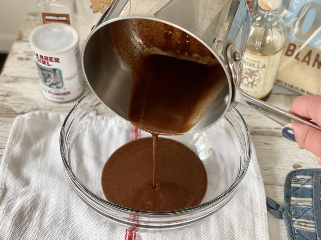 pouring melted chocolate and butter into a bowl for Keto Kitchen Sink Brownies