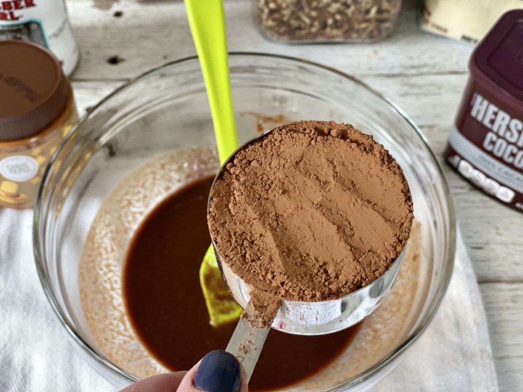 adding cocoa powder to Keto Kitchen Sink Brownies batter