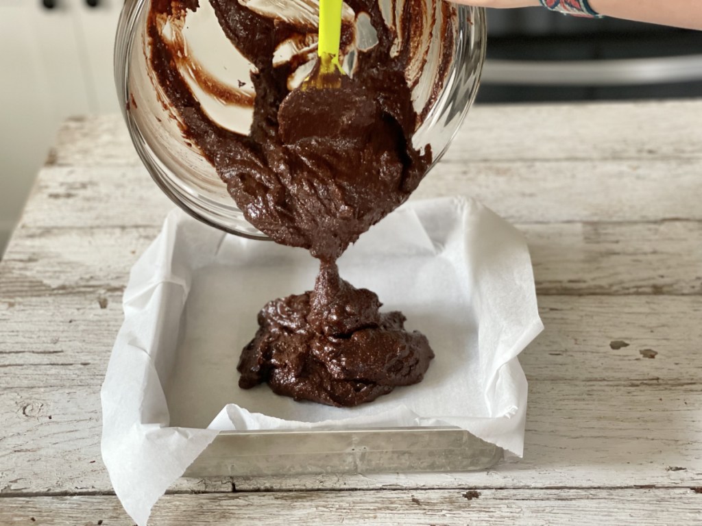 pouring Keto Kitchen Sink Brownies into a baking dish