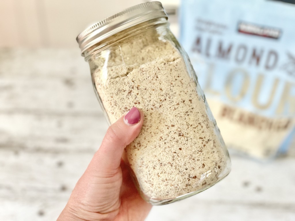 holding a jar of natural almond flour