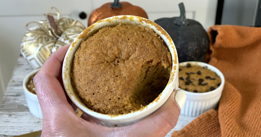 holding keto pumpkin mug cake with bite out of it 