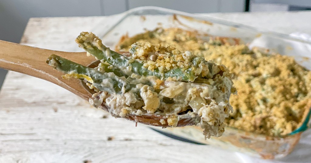 scoop of keto green bean casserole on wooden spoon