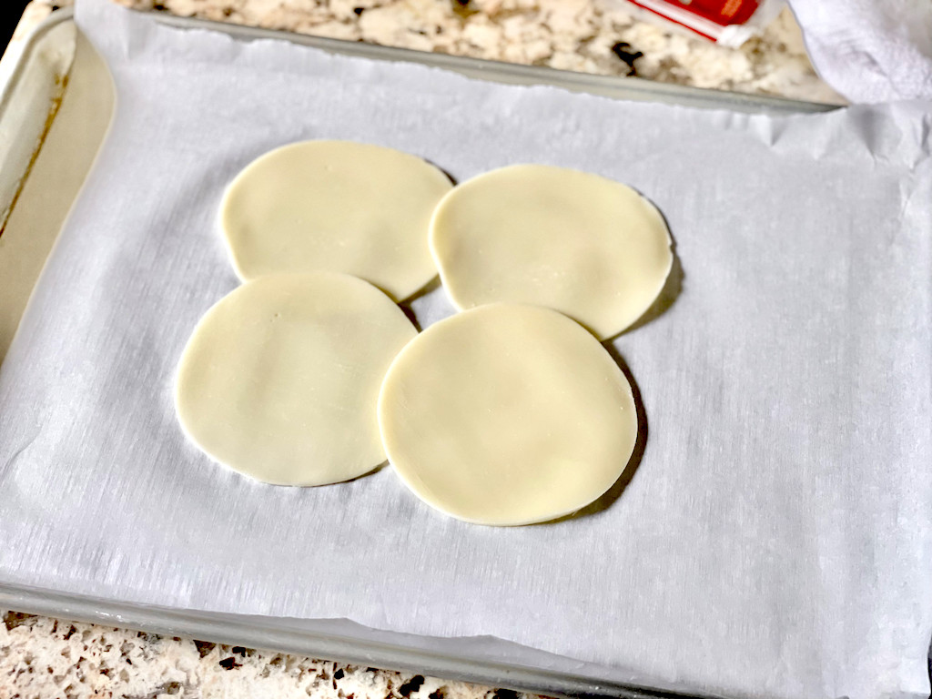 provolone cheese slices on parchment lined pan 