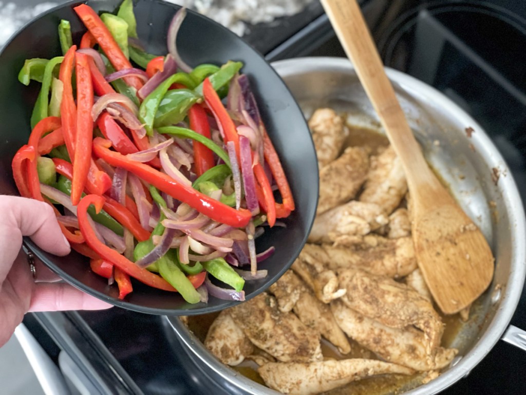 adding veggies to skillet for Easy keto skillet chicken fajitas