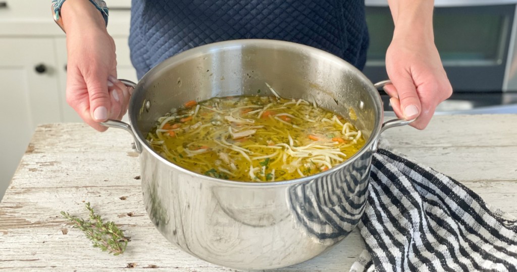 holding pot of Keto Chicken Noodle Soup