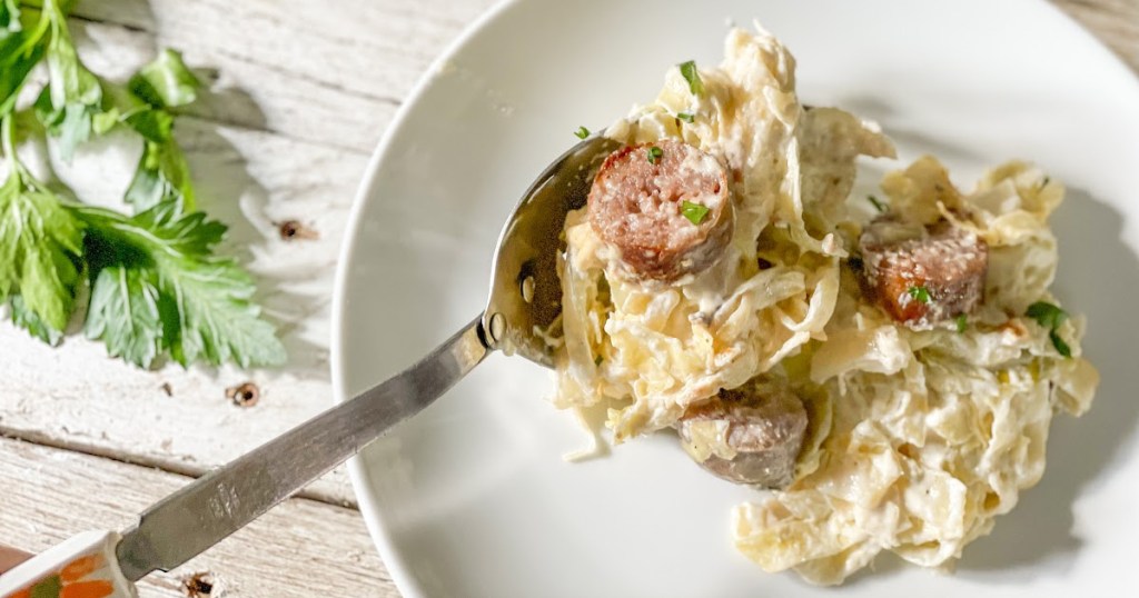 scooping Keto Sausage Alfredo with Cabbage
