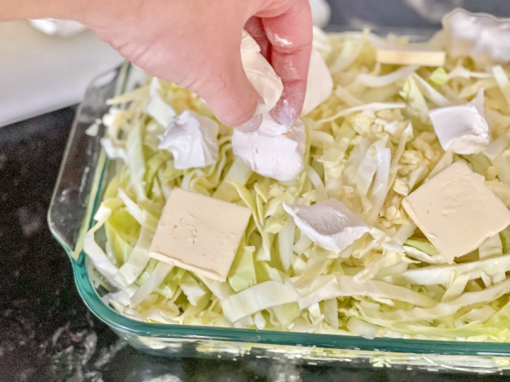 adding cream cheese to Keto Sausage Alfredo with Cabbage