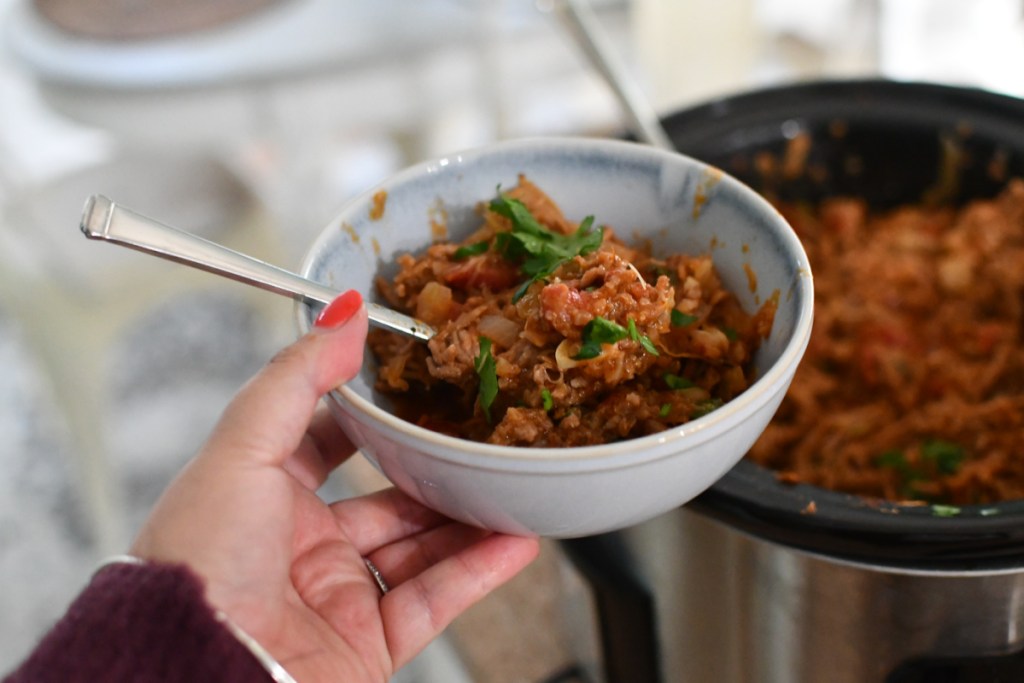 holding a bowl of cabbage roll casserole