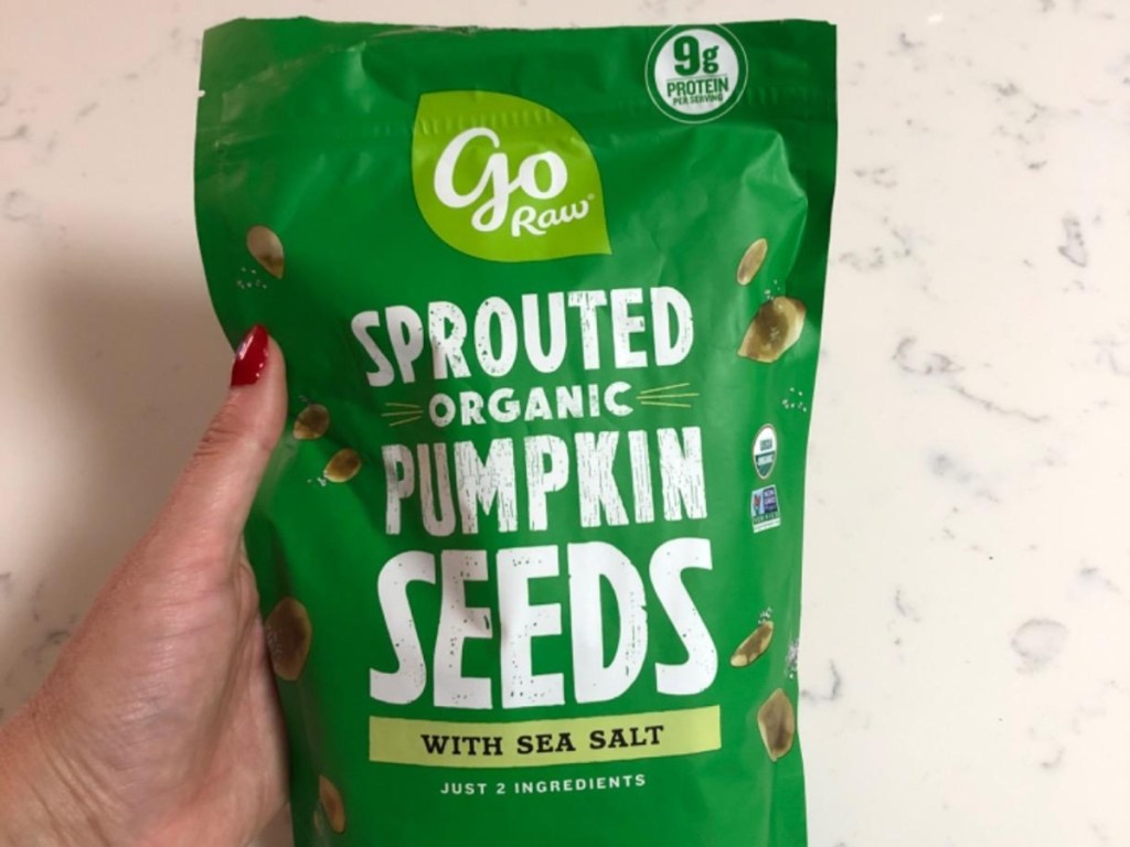 holding a bag of salted pumpkin seeds