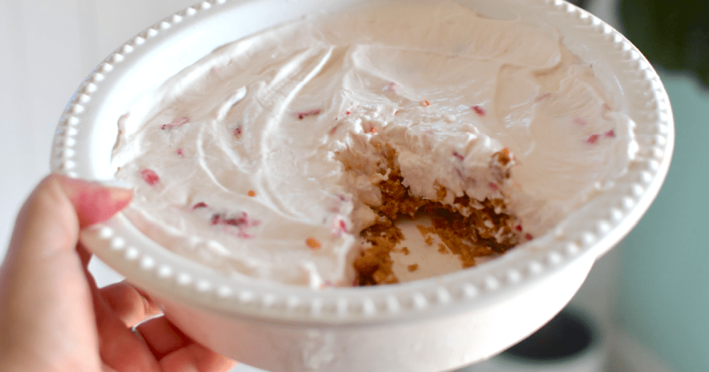 holding pie plate filled with yogurt cream pie 