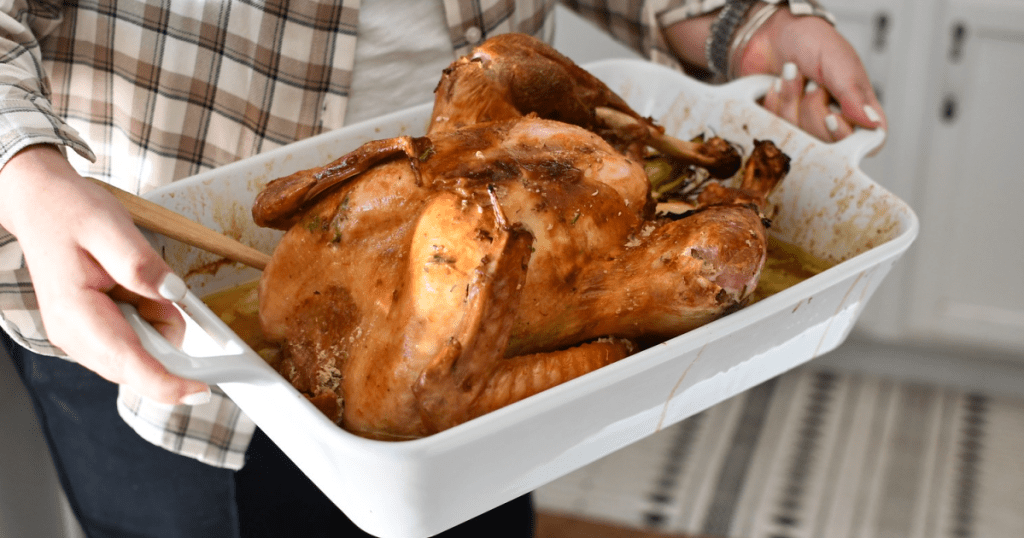 holding roasted turkey in casserole dish 