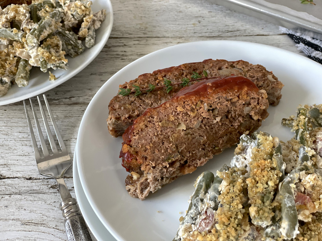 keto meatloaf slices on plate with green bean casserole 