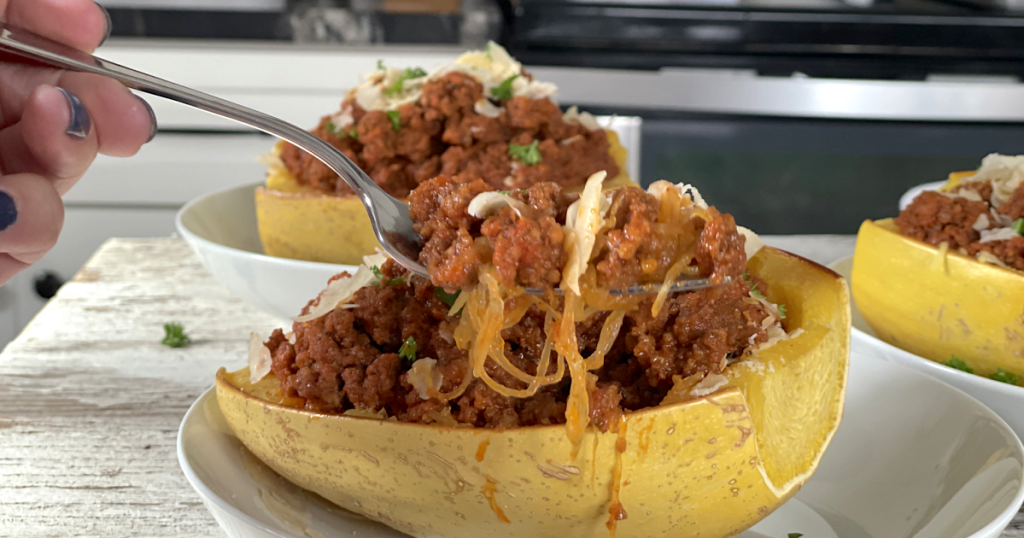 taking bite of beefy marinara spaghetti squash