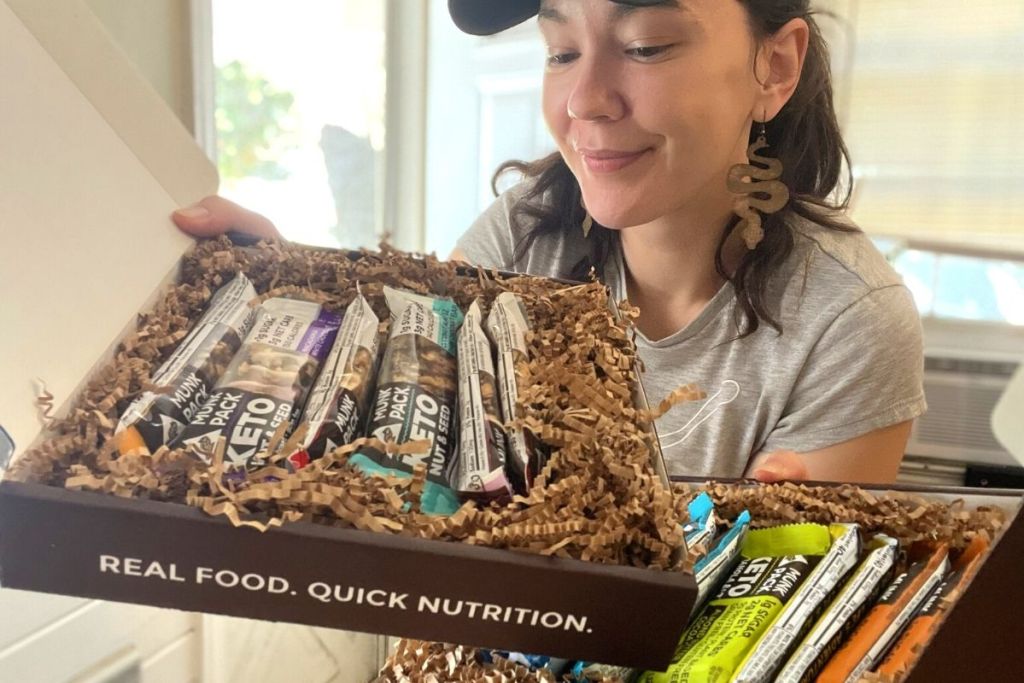 woman holding keto nut and seed granola bars
