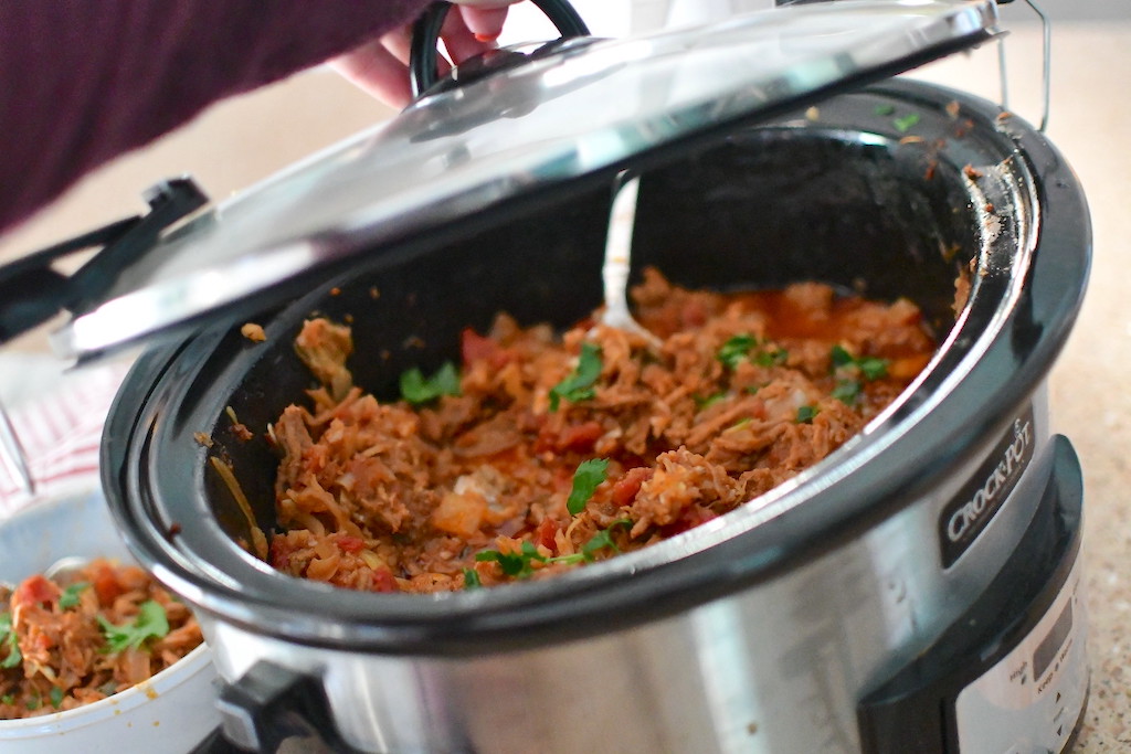 opening Crockpot with cabbage roll casserole inside 