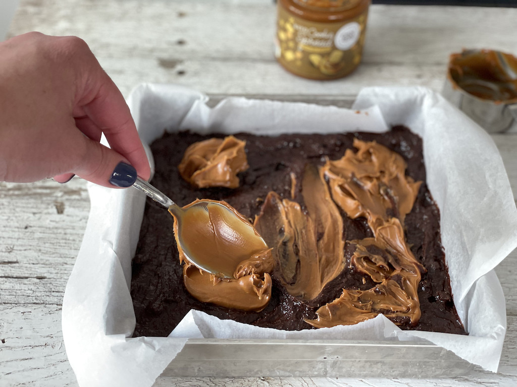 spreading cookie butter on keto brownies 