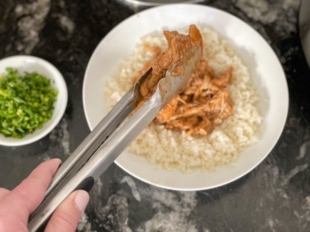 putting keto crockpot bourbon chicken over cauliflower rice