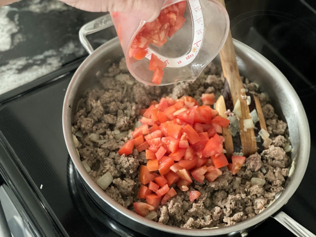 adding tomatoes to browned ground beef for slow cooker low-carb lasagna
