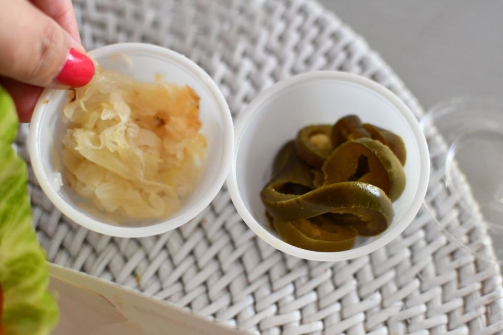 small container of pickled jalapenos and sauerkraut