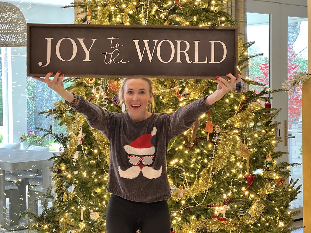 woman holding Joy to the World Christmas sign
