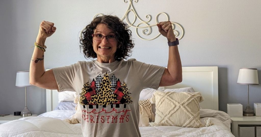 woman wearing a Christmas shirt in front of tree