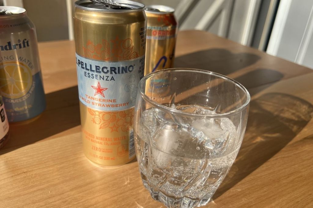 can of San Pellegrino tangerine & strawberry sparkling water next to glass